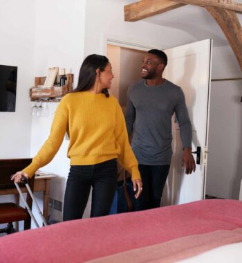 Couple Spending Romantic Weekend Away Opening Door Of Hotel Room