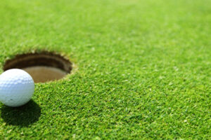 golf ball on lip of cup close up